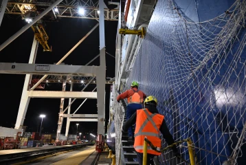 Container ship night works up gangway