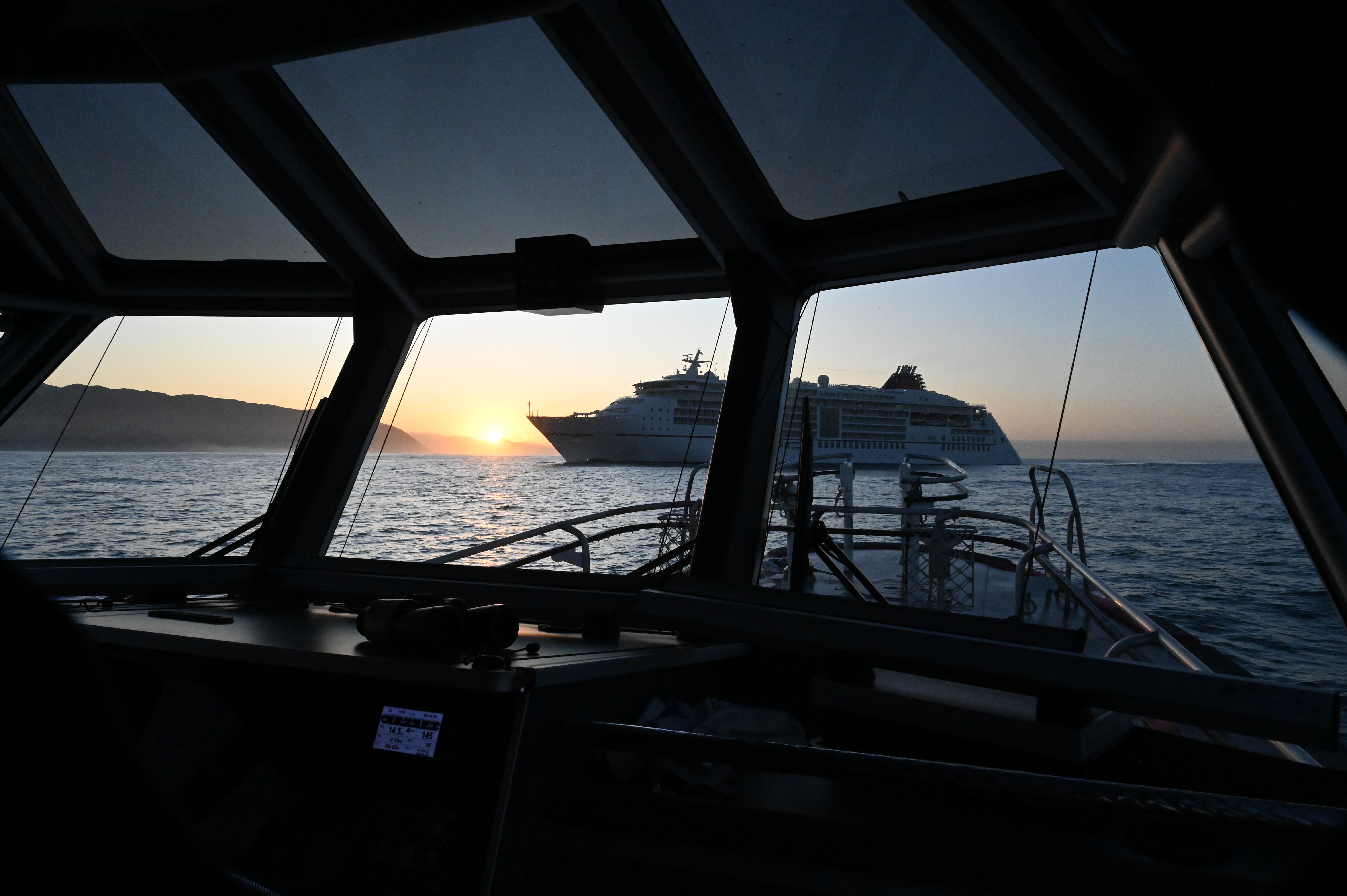 A cruise ship at sunrise through the windshield of Pilot Boat Te HAA