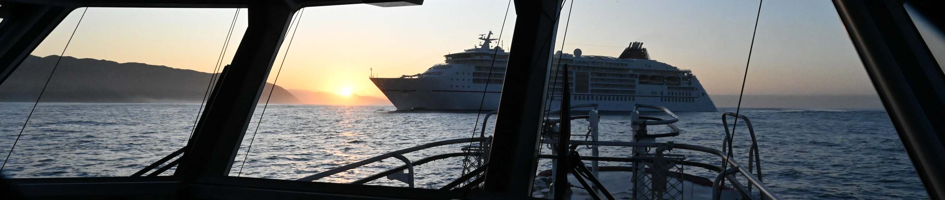 A cruise ship at sunrise through the windshield of Pilot Boat Te HAA